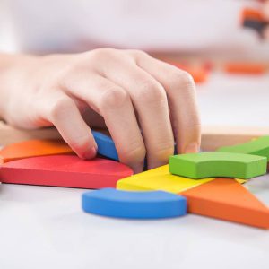 Uśmiechnięte dzieci podczas terapii podnoszą ręce do góry – zabawa i wsparcie rozwoju