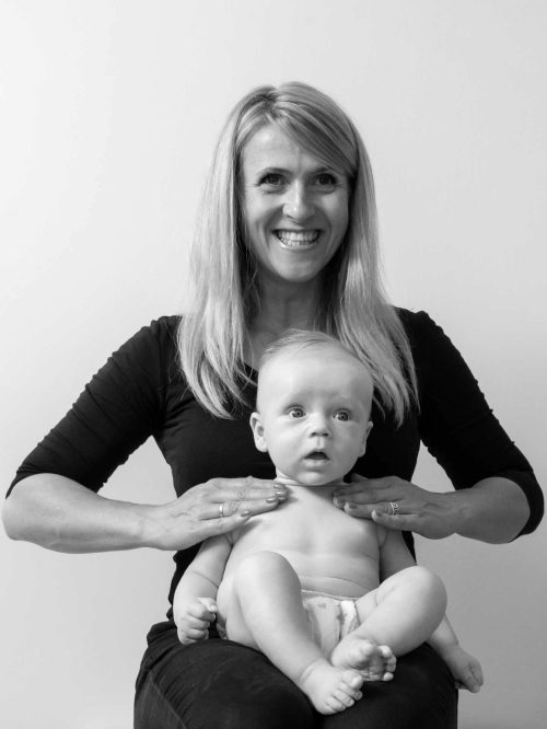 Rehabilitacja neurologiczna - dziecko siedzi na kolanach terapeuty, który dotyka jego klatki piersiowej